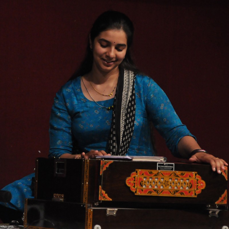 Musician practicing harmonium during an Indian music session
